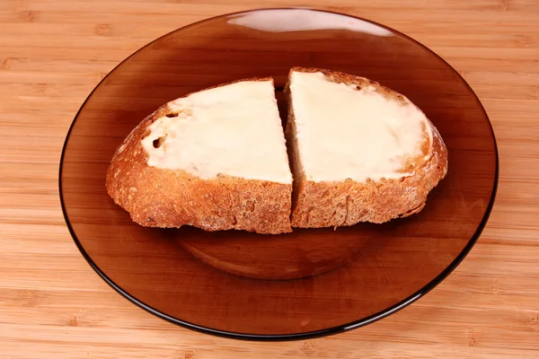Fette di pane imburrato su un piatto — Foto Stock