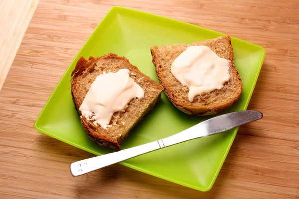 Bröd med smör i grön plåt — Stockfoto