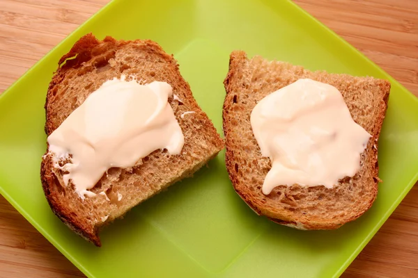 Pan con mantequilla en plato verde —  Fotos de Stock
