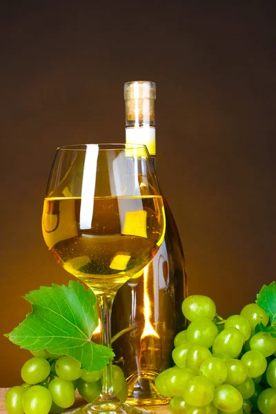 Copa de vino, botella y uvas sobre fondo amarillo — Foto de Stock