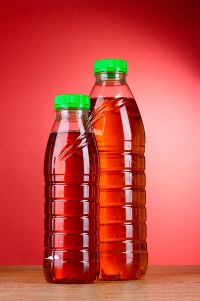 Flessen met SAP op rode achtergrond — Stockfoto