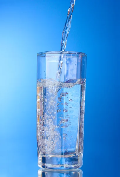 Наливаємо воду на склянку — стокове фото
