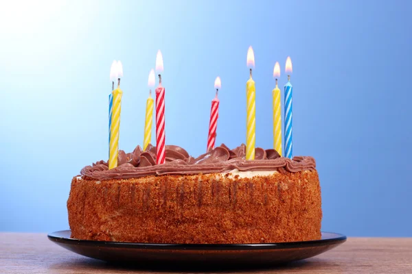 Торт со свечами на синем фоне — стоковое фото