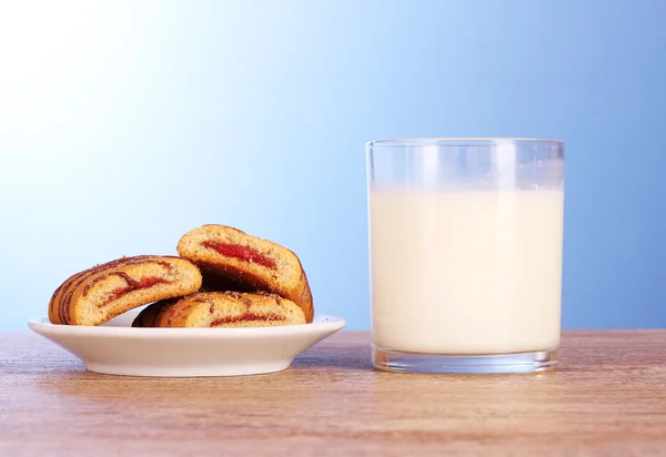 Sušenky s mlékem na modrém pozadí — Stock fotografie