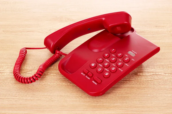 Red phone on wooden table — Stock Photo, Image