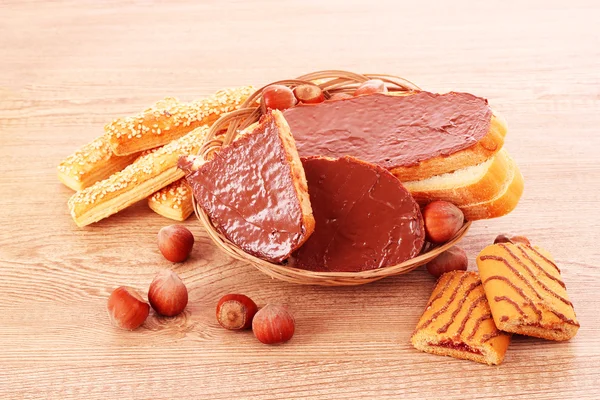 Pane, biscotti e noci con cioccolato sul tavolo di legno — Foto Stock