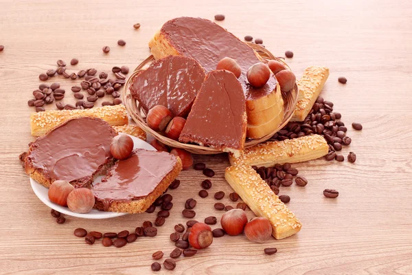 Brood, koekjes en noten met chocolade op houten tafel — Stockfoto