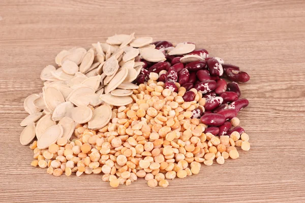 Peas, beans and seeds on brown — Stock Photo, Image