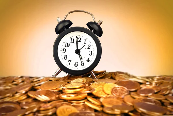 Relógio despertador com moedas de ouro no fundo amarelo — Fotografia de Stock