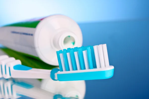 Tandpasta en penseel op een blauwe achtergrond — Stockfoto