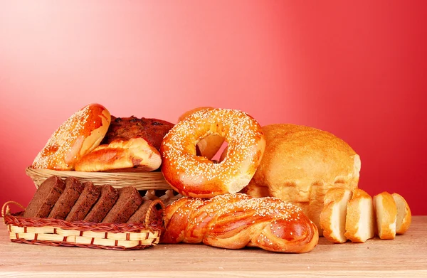 Bakade bröd sortiment på röd bakgrund — Stockfoto