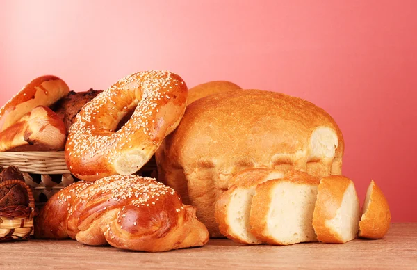 Pečený chléb sortimentu na červeném pozadí — Stock fotografie