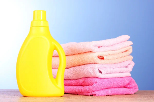Towels and bottle on blue background — Stock Photo, Image