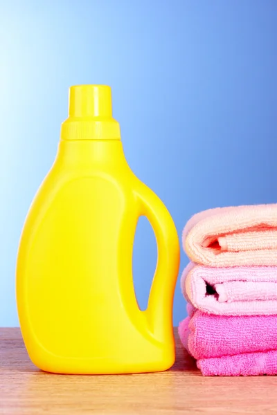 Asciugamani e bottiglia su sfondo blu — Foto Stock