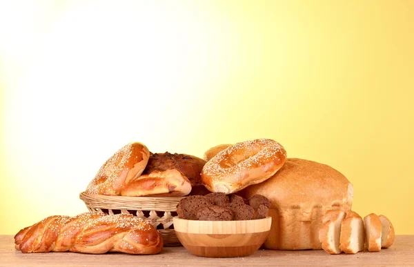 Baked bread assortment on yellow background — Stock Photo, Image
