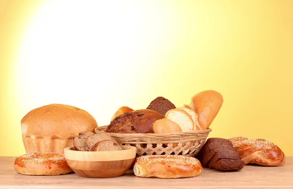 Surtido de pan horneado sobre fondo amarillo —  Fotos de Stock