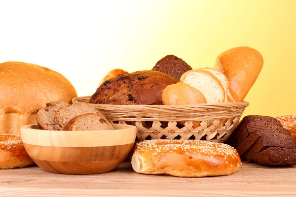 Gebackenes Brotsortiment auf gelbem Hintergrund — Stockfoto