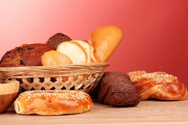 Pişmiş ekmek çeşitler kırmızı zemin üzerine — Stok fotoğraf