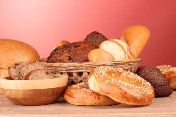 Baked bread assortment on red background — Stock Photo, Image