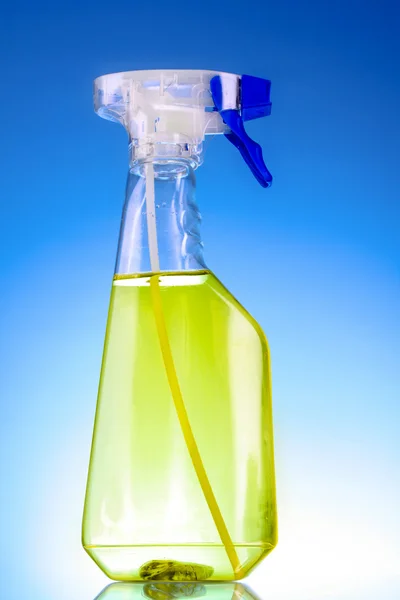 Botella de spray amarillo sobre fondo azul — Foto de Stock