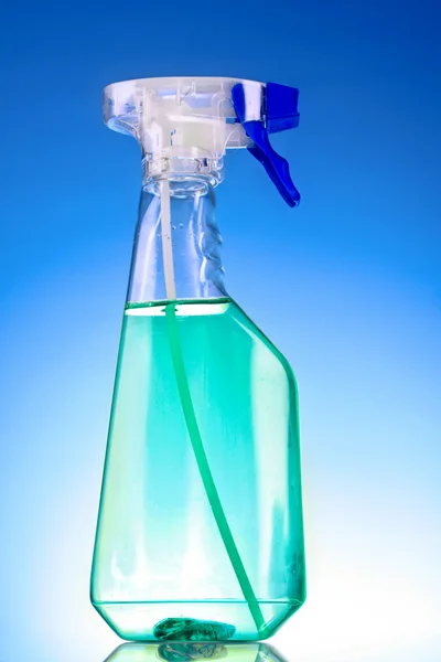 Розпилювальна пляшка на синьому фоні — стокове фото