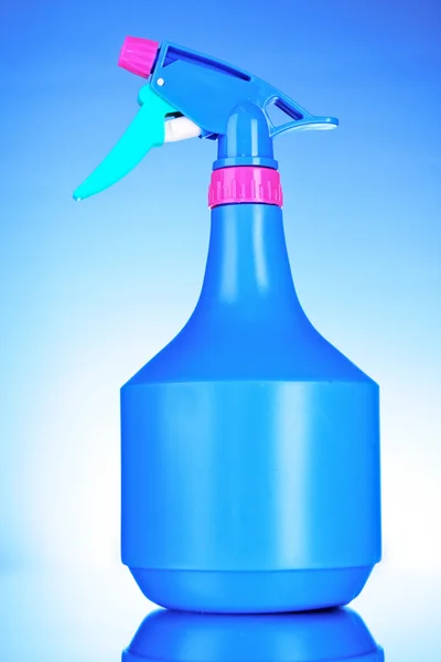 Blauwe spray fles op blauwe achtergrond — Stockfoto
