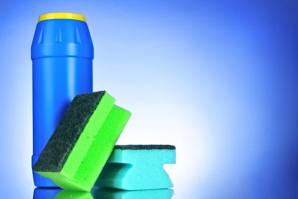 Powder bottle and sponge on blue background — Stock Photo, Image