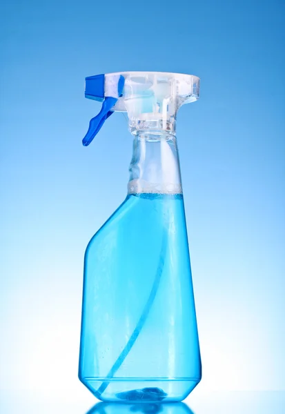 Láhev s rozprašovačem na modrém pozadí — Stock fotografie