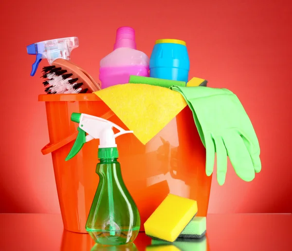 Cleaning supplies on red background — Stock Photo, Image