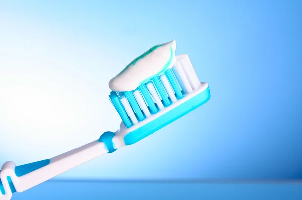 Зубная щетка с зубной пастой на синем фоне — стоковое фото