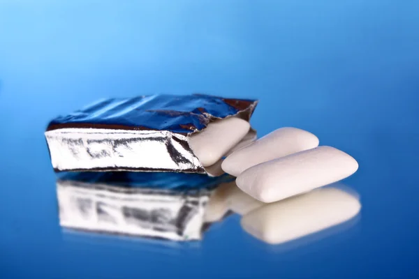 Žvýkací guma na modrém pozadí — Stock fotografie