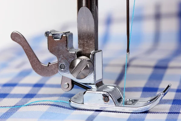 Швейная машина и синяя ткань — стоковое фото
