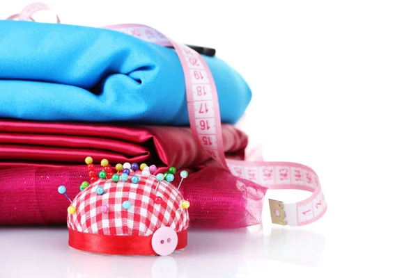 Red, blue and pink thread, measuring tape and fabric — Stock Photo, Image