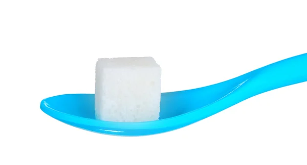 Zucchero grumo in cucchiaio di plastica blu isolato su bianco — Foto Stock