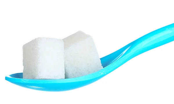 Bryła cukru w niebieski łyżka z tworzywa sztucznego na białym tle — Zdjęcie stockowe