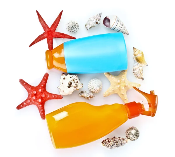 Sonnencreme in Flaschen und Muscheln isoliert auf weiß — Stockfoto