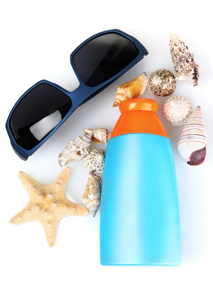 Kremów z filtrami w butelce, okulary i muszle na białym tle — Zdjęcie stockowe