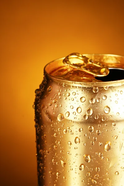Boite de conserve en or sur fond jaune. Focus sur la goutte d'eau la plus proche — Photo