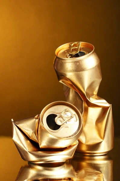 Crumpled golden tin can on a yellow background — Stock Photo, Image