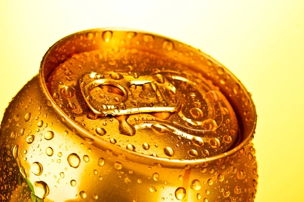 Golden metallic beer with water drops on yellow background — Stock Photo, Image