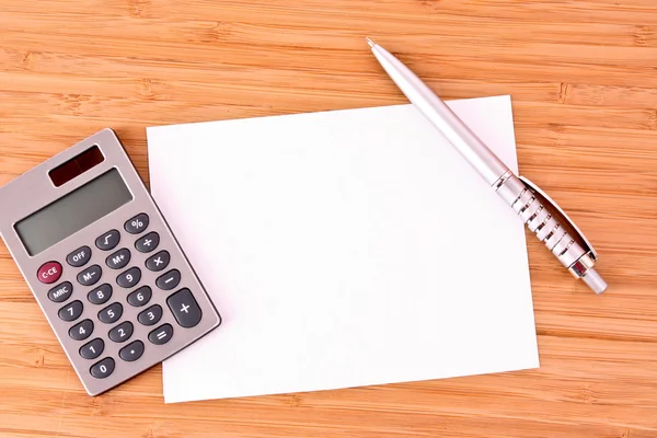 Ett ark papper och penna, en räknare på ett träbord — Stockfoto