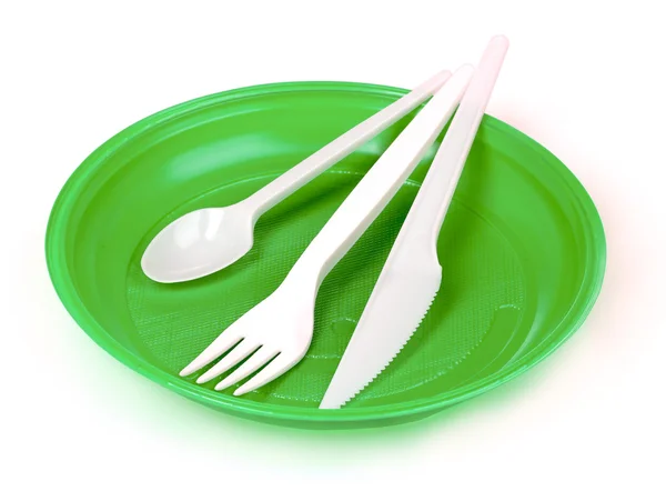 Plastic cutlery on green plate — Stock Photo, Image