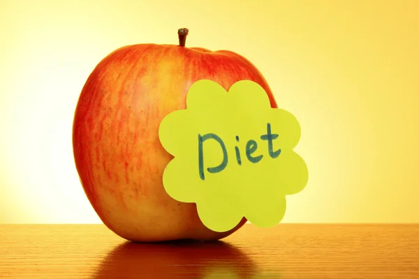 Apple with "Diet" label on yellow background — Stock Photo, Image