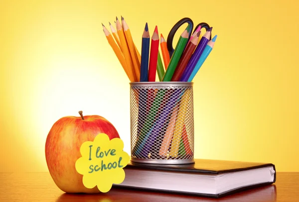 Stationery and apple with "I love school" on yellow background — Stock Photo, Image