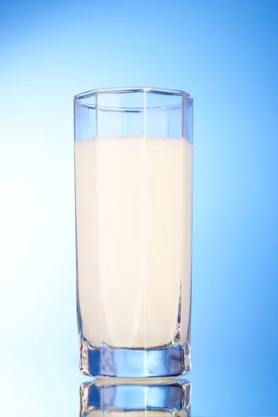 Vaso con leche sobre fondo azul — Foto de Stock