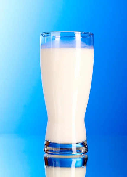 Sklo s mlékem na modrém pozadí — Stock fotografie