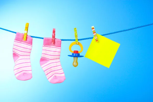 Babybooties, Brustwarzen und gelbe Karte auf blauem Hintergrund — Stockfoto