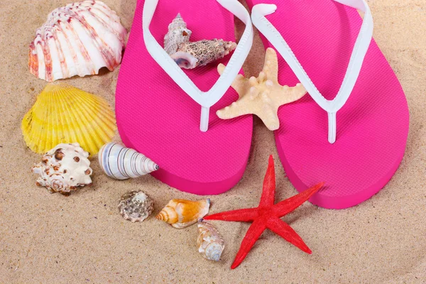 Plážovou obuv, skořápky a hvězdice na písku — Stock fotografie