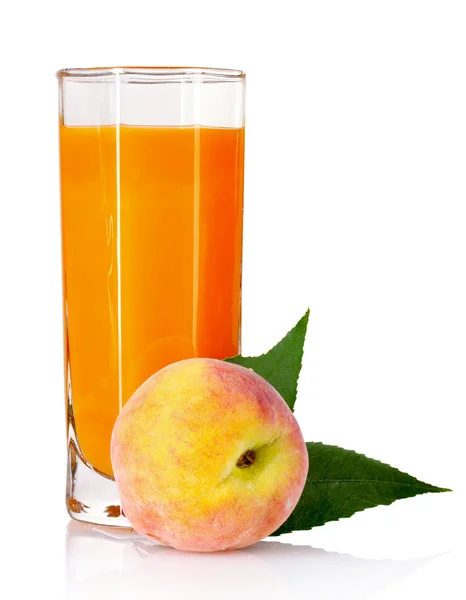 Färska persikor och glas med juice — Stockfoto