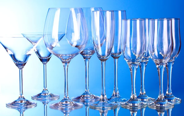 Pocas copas de vino vacías sobre fondo azul —  Fotos de Stock